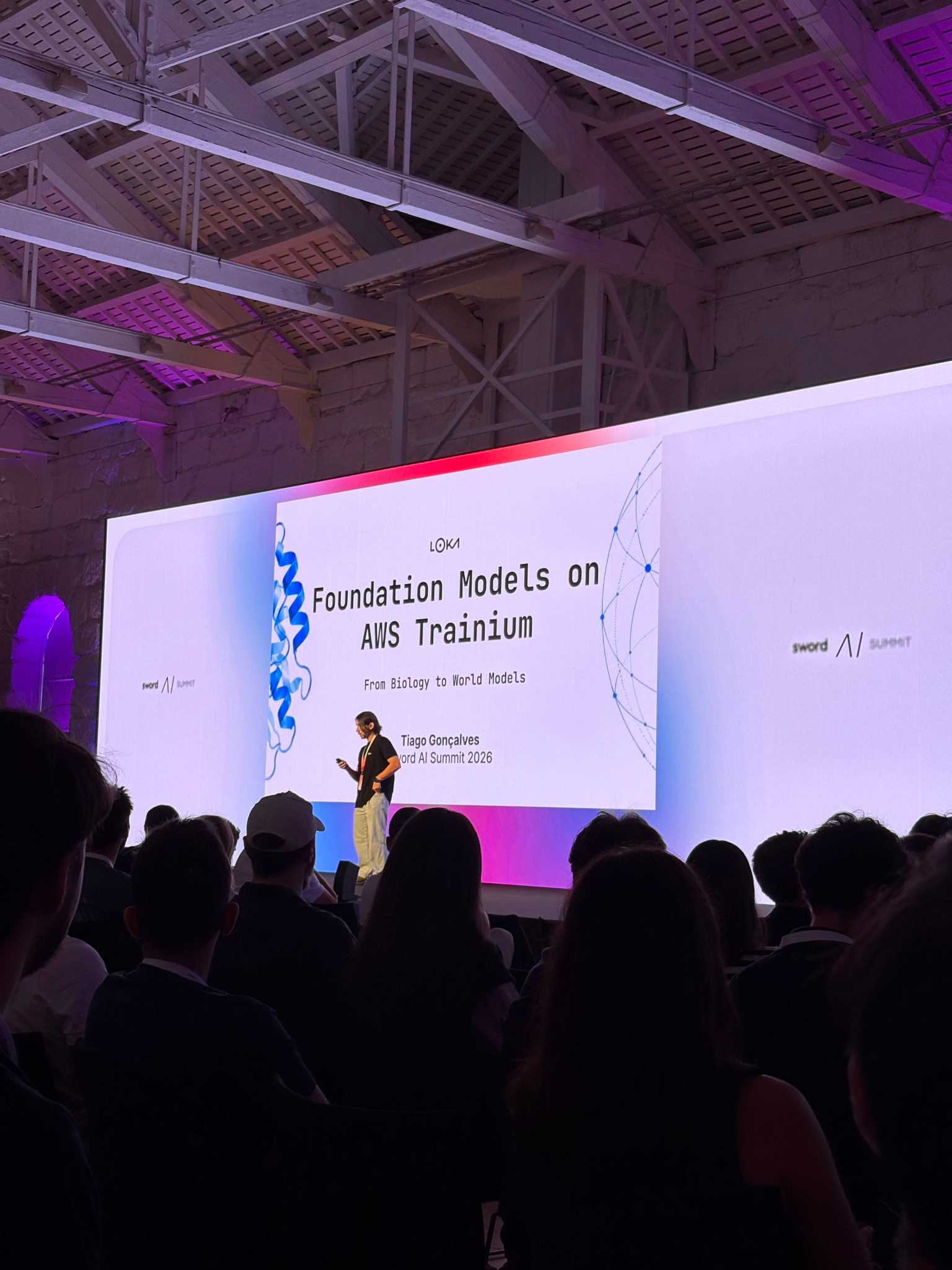 Tiago Gonçalves presents Foundation Models on AWS Trainium to an audience at Sword AI Summit 2026 in Portugal.